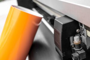 גליל ויניל צהוב ליד מכונת דפוס.